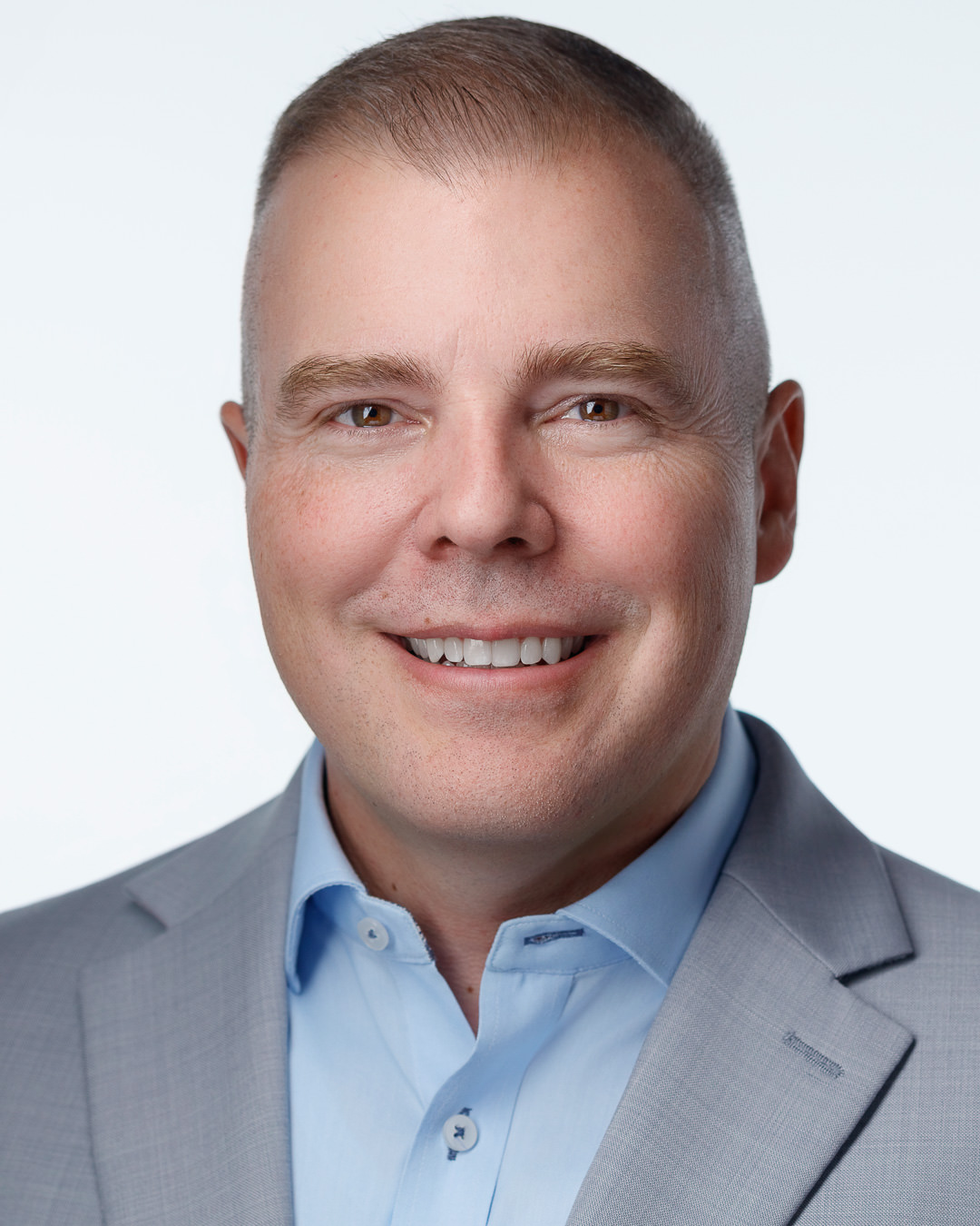 Aaron Siegel, Enrolled Agent, smiling in a gray blazer and light blue shirt